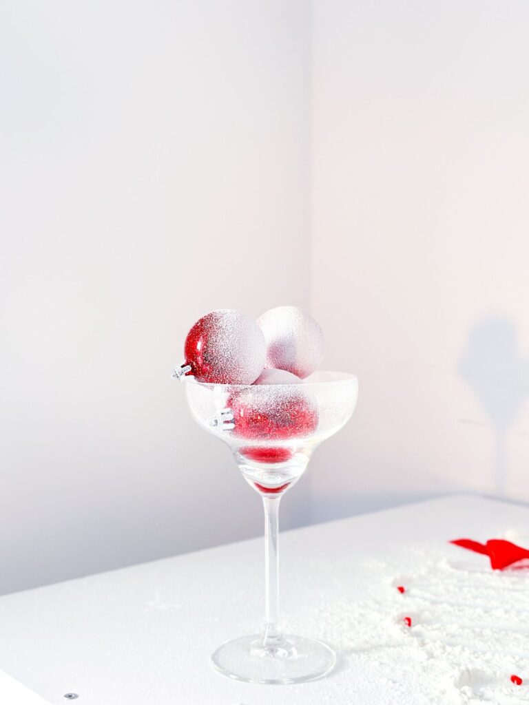 Red glass Christmas ornaments filling a stemmed glass
