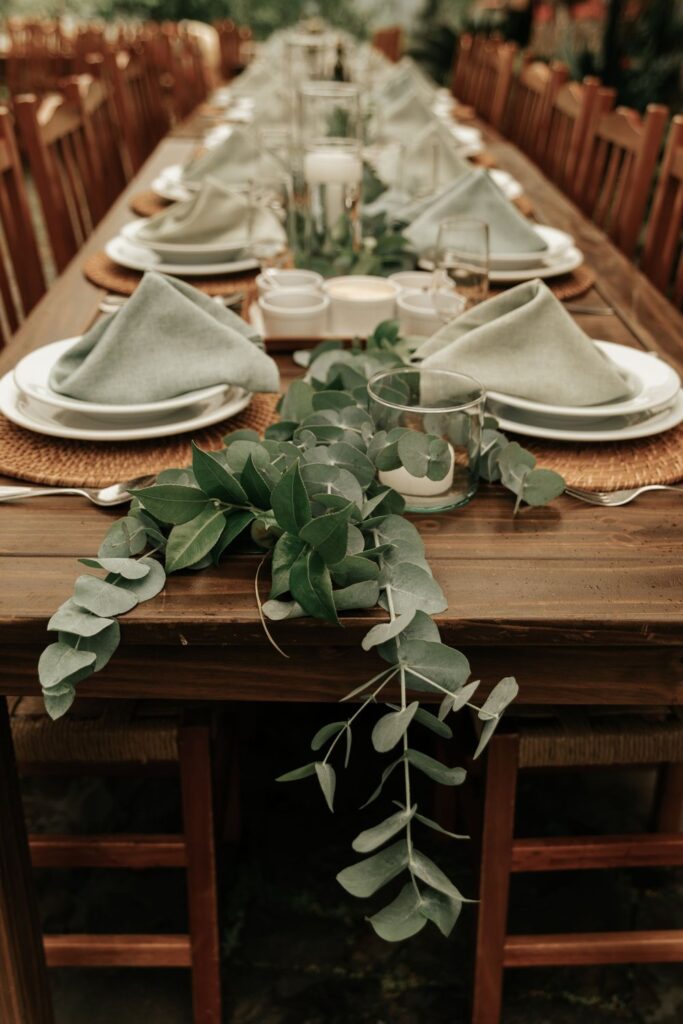 Long dinner table with a eucalyptus garland running down the center