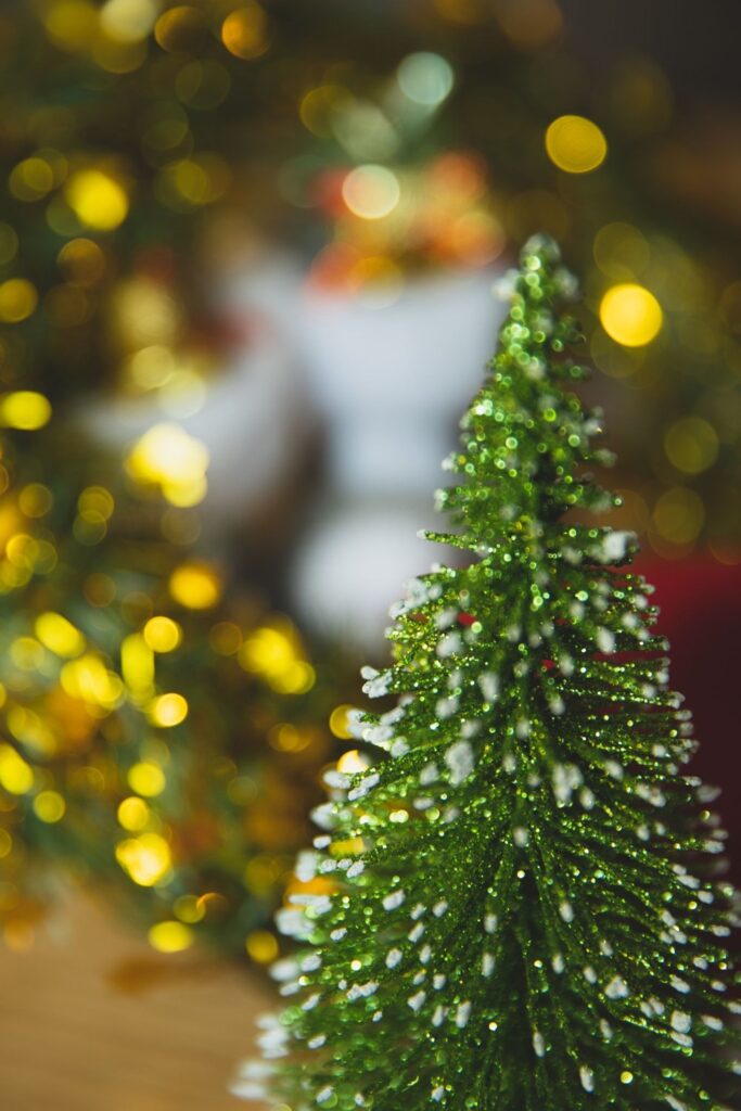 Glittery miniature bottle-brush Christmas tree with bokeh lights