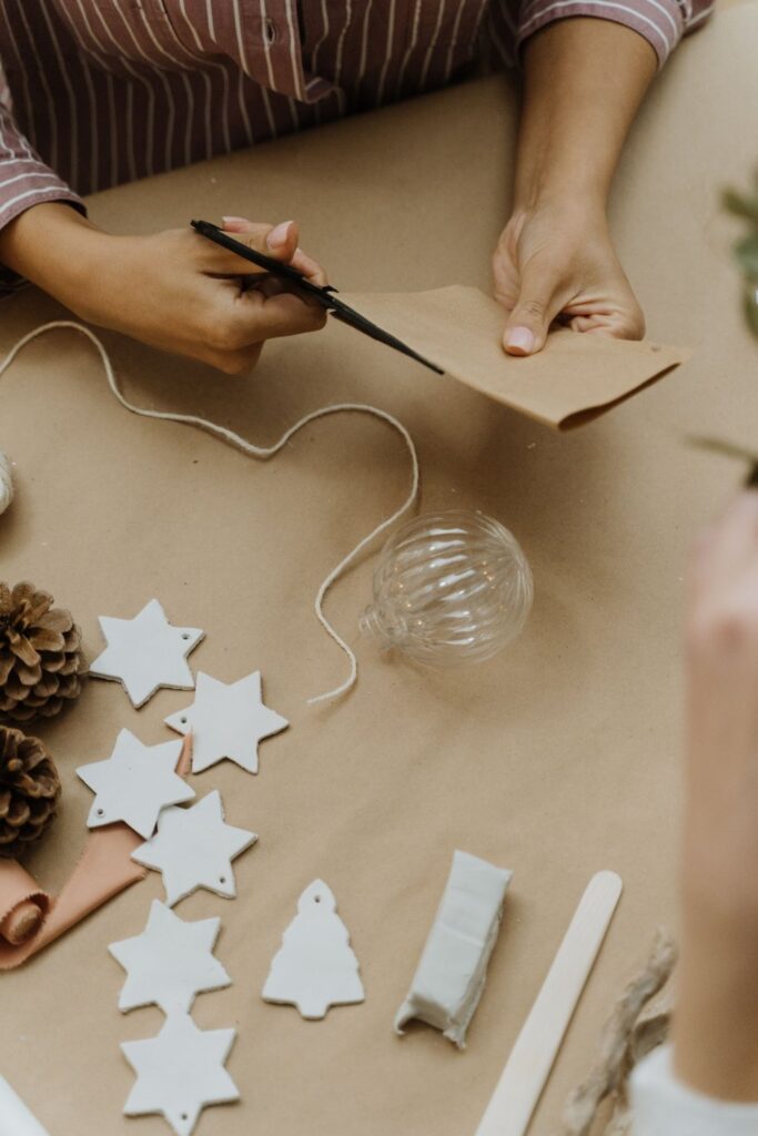 Cutting paper star and tree shapes on a craft table
