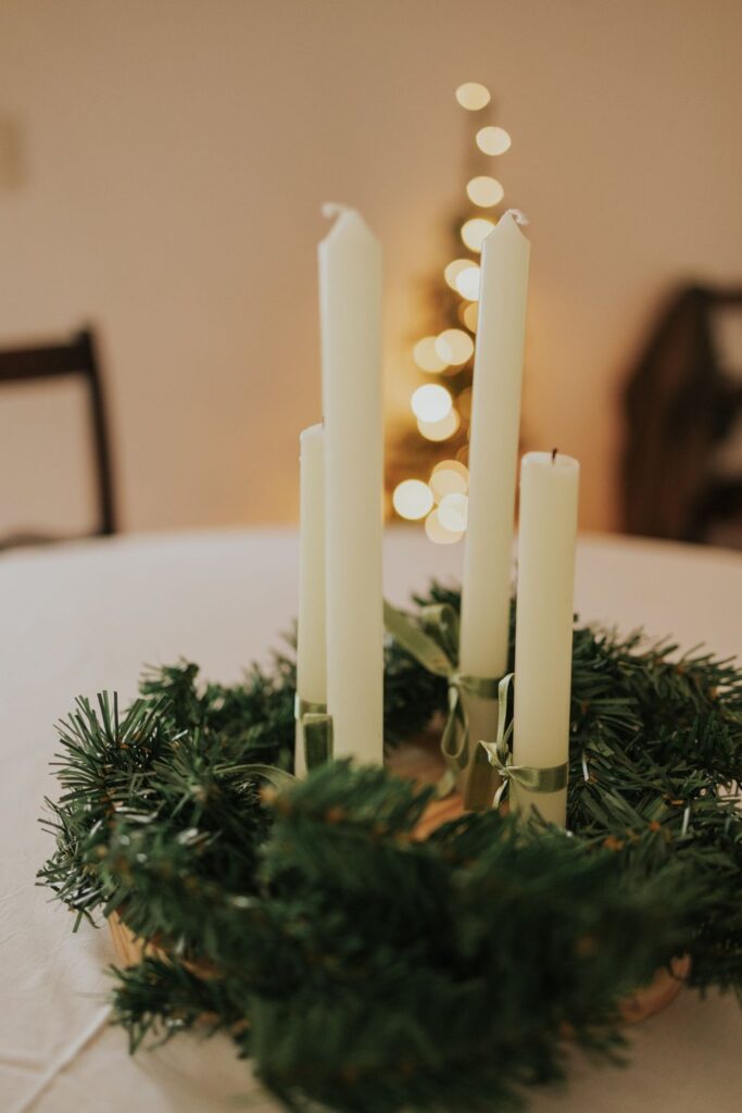 Cream taper candles standing in a ring of evergreen