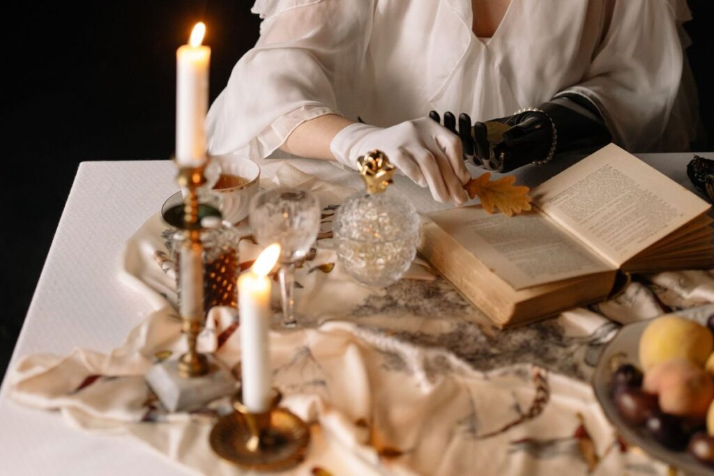 Lit taper candles in assorted brass candle holders on a table