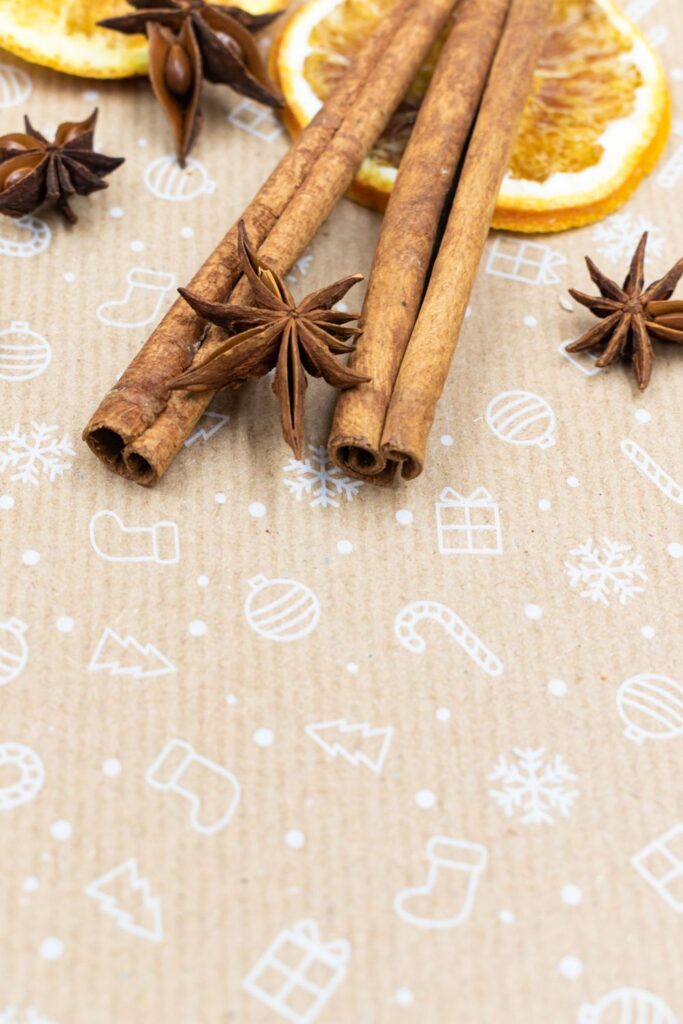 Cinnamon sticks and star anise on festive patterned paper