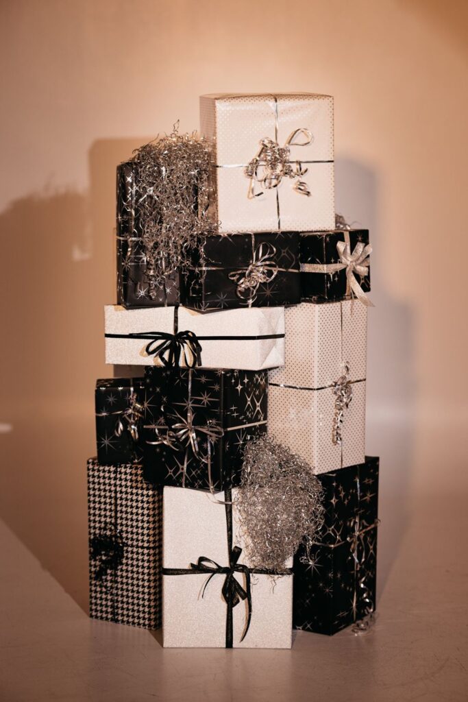 Stack of black and white wrapped gift boxes with silver ribbon