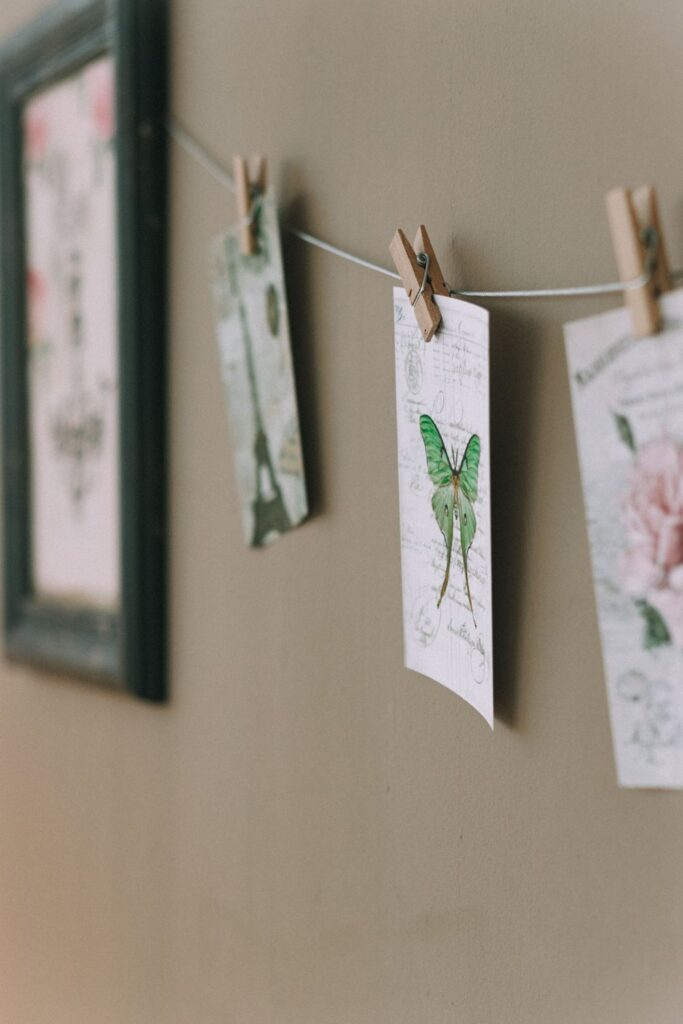 Paper cards clipped to a string on a wall with clothespins