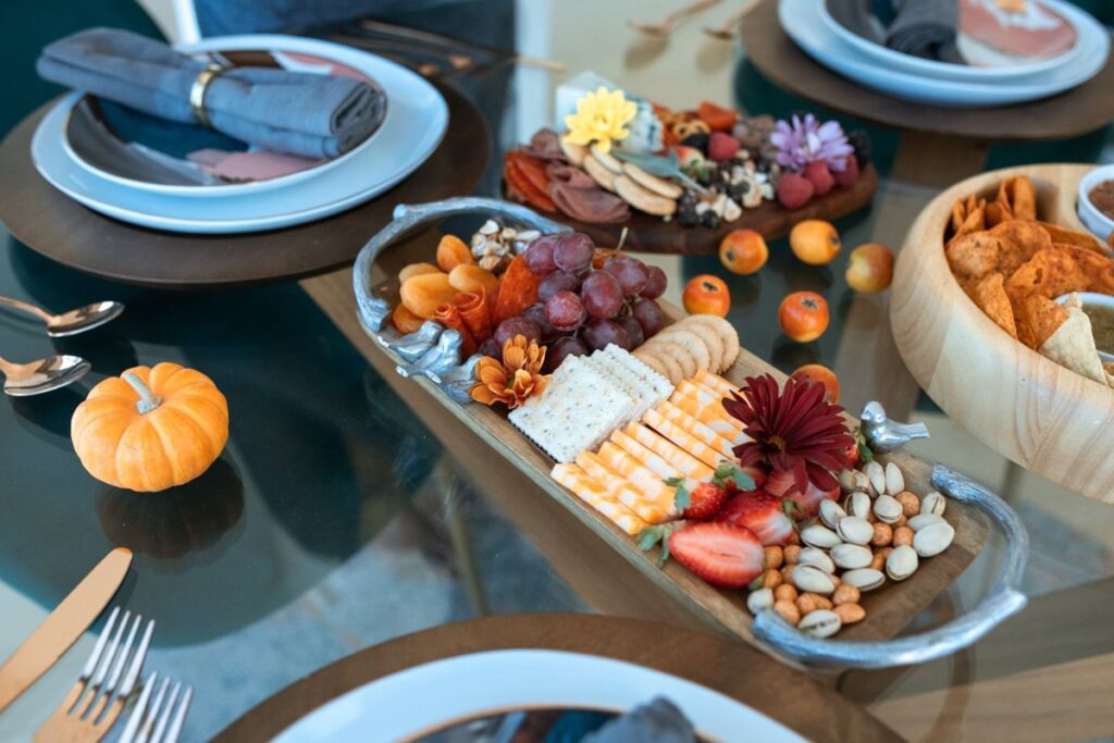 Charcuterie board with cheese, fruit and nuts on a fall table