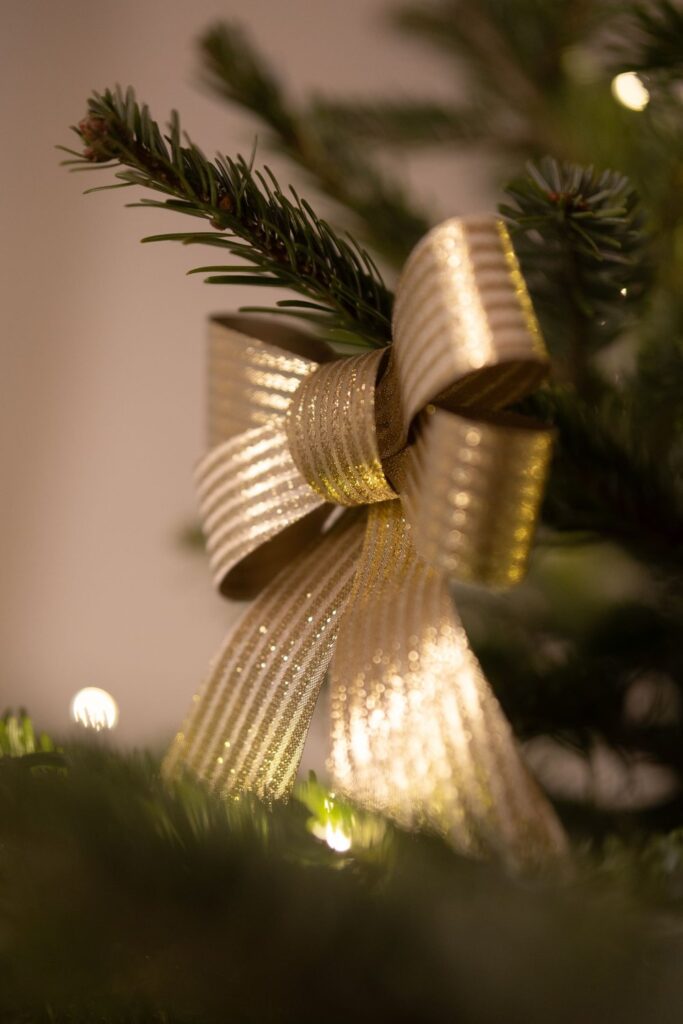 Gold ribbon decoration tied on a Christmas tree branch