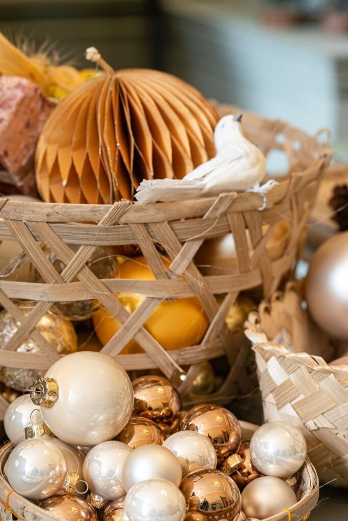 Woven baskets filled with gold and white Christmas ornaments