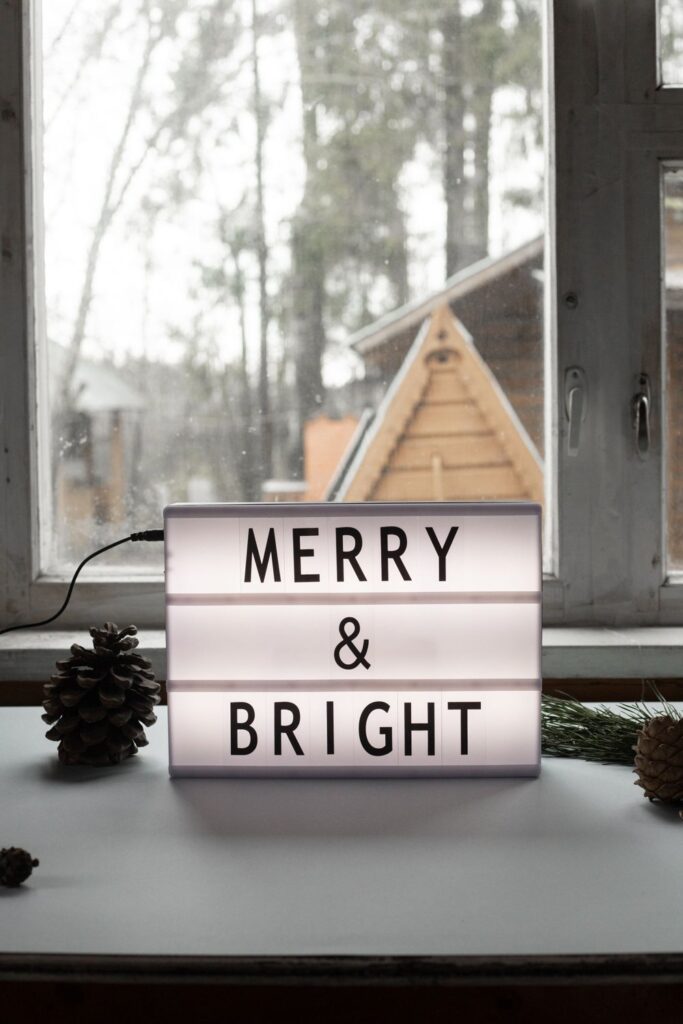 Light box sign reading Merry and Bright on a windowsill